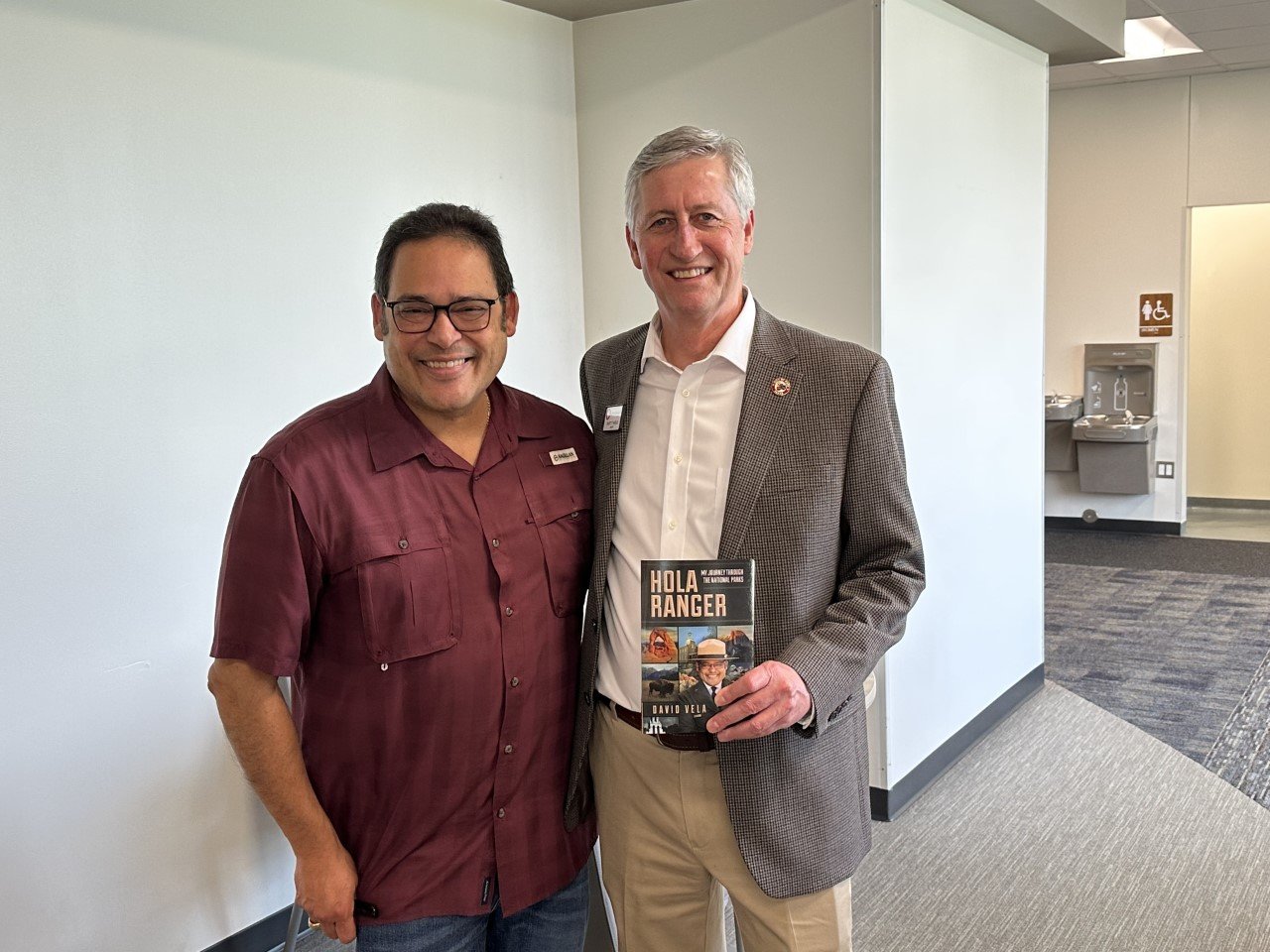 David Vela, former national parks administrator (left), presents Mayor Dusty Thiele with a copy of his memoir, Hola Ranger. Vela, formerly of Wharton, was the featured speaker at the Jan. 11 Katy Area Retired Educators meeting. He shared some of his experiences over his decades-long career.